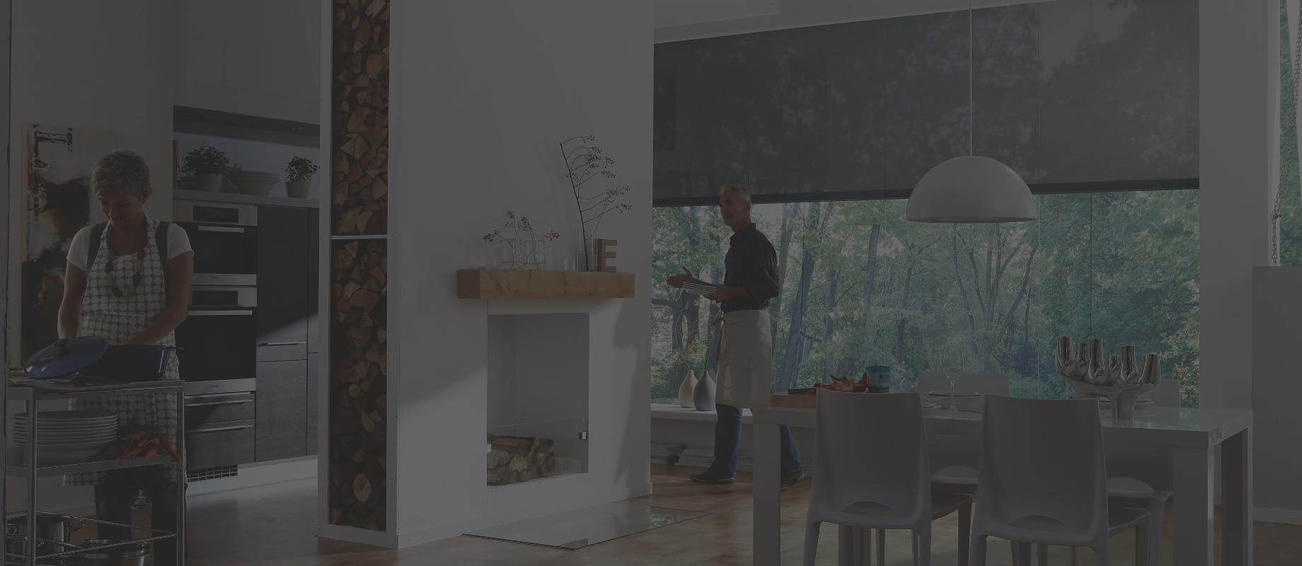 Femme cuisinant dans une cuisine ouverte donnant sur la salle à manger + un homme